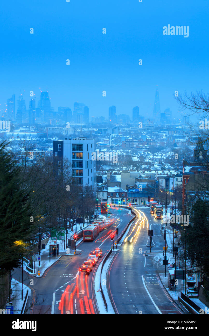Moving traffic on an urban highway, London skyline, winter view with snow, Archway road, London, UK Stock Photo