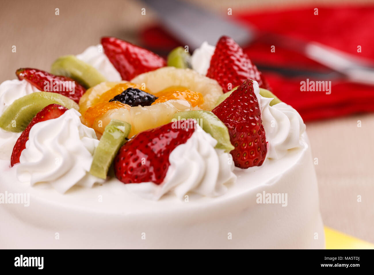 A close up of a white cake topped with various fruits Stock Photo - Alamy