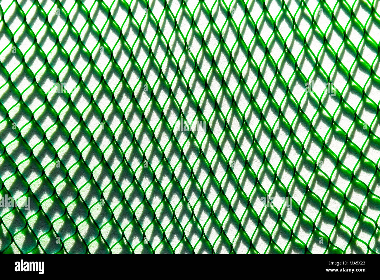 Green net casting the big shadow on the white soft background surface Stock Photo