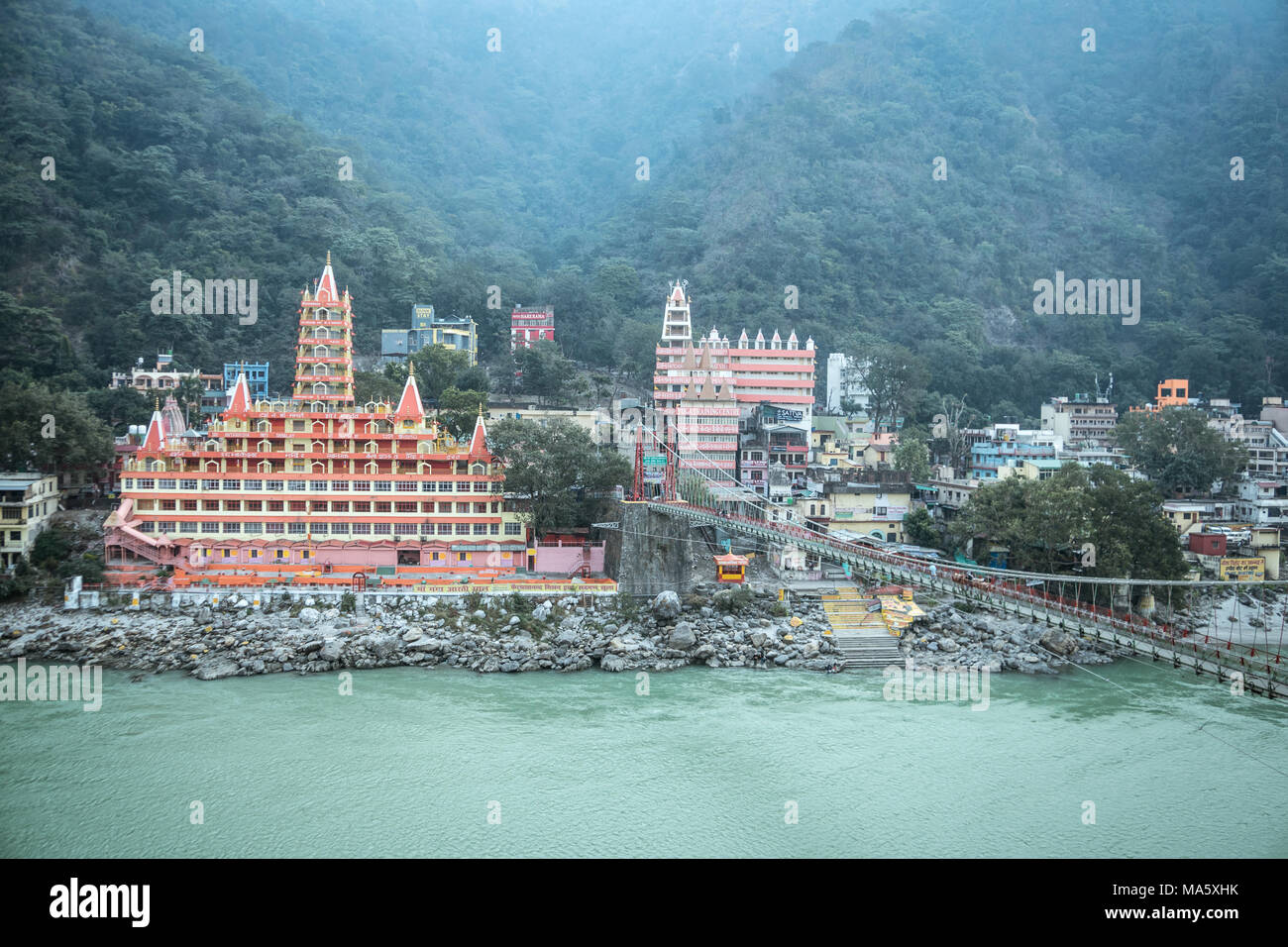 View of Ganga river embankment, Lakshman Jhula bridge and Tera Manzil Temple, Trimbakeshwar in Rishikesh INDIA - January 11, 2018: Stock Photo