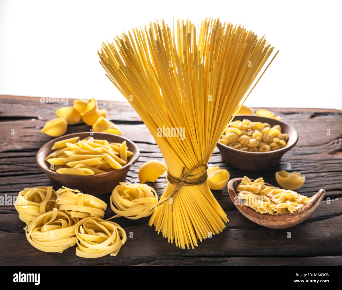 Different pasta types on wooden table. White background. Stock Photo