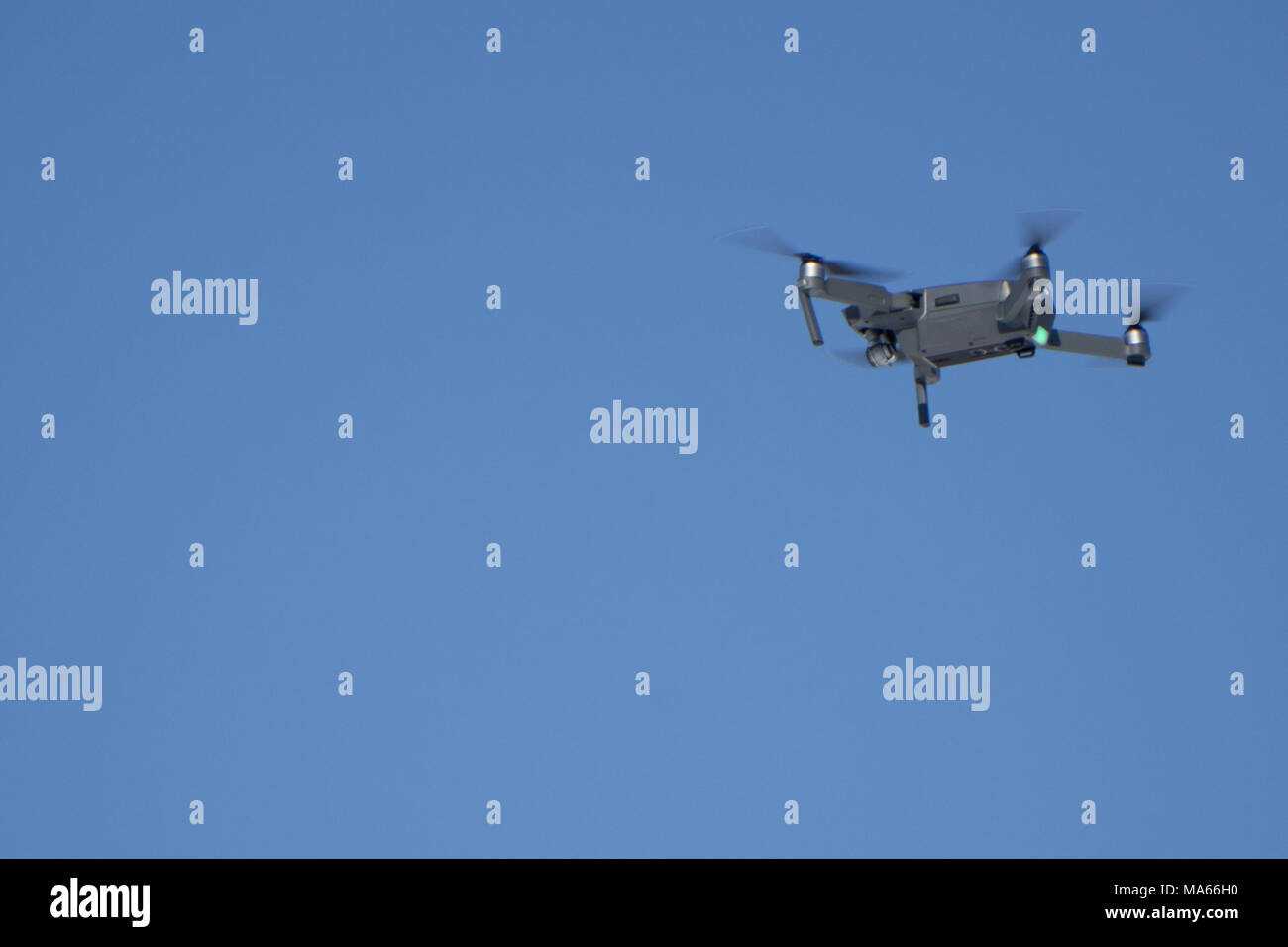 Drone Quadcopter with camera flying on a clear sky background Stock Photo