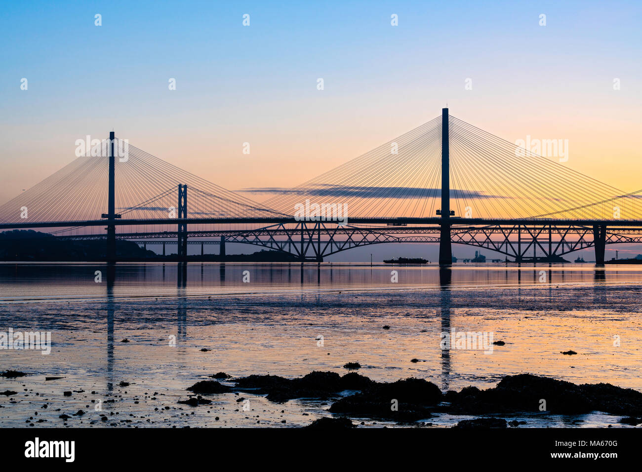 Sunrise view of the three major bridges crossing the Firth of Forth at South Queensferry; Queensferry Crossing, North Road Bridge and the Forth Bridge Stock Photo