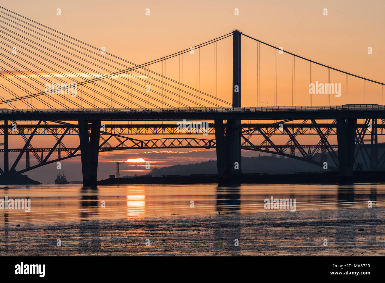 Sunrise view of the three major bridges crossing the Firth of Forth at South Queensferry; Queensferry Crossing, North Road Bridge and the Forth Bridge Stock Photo