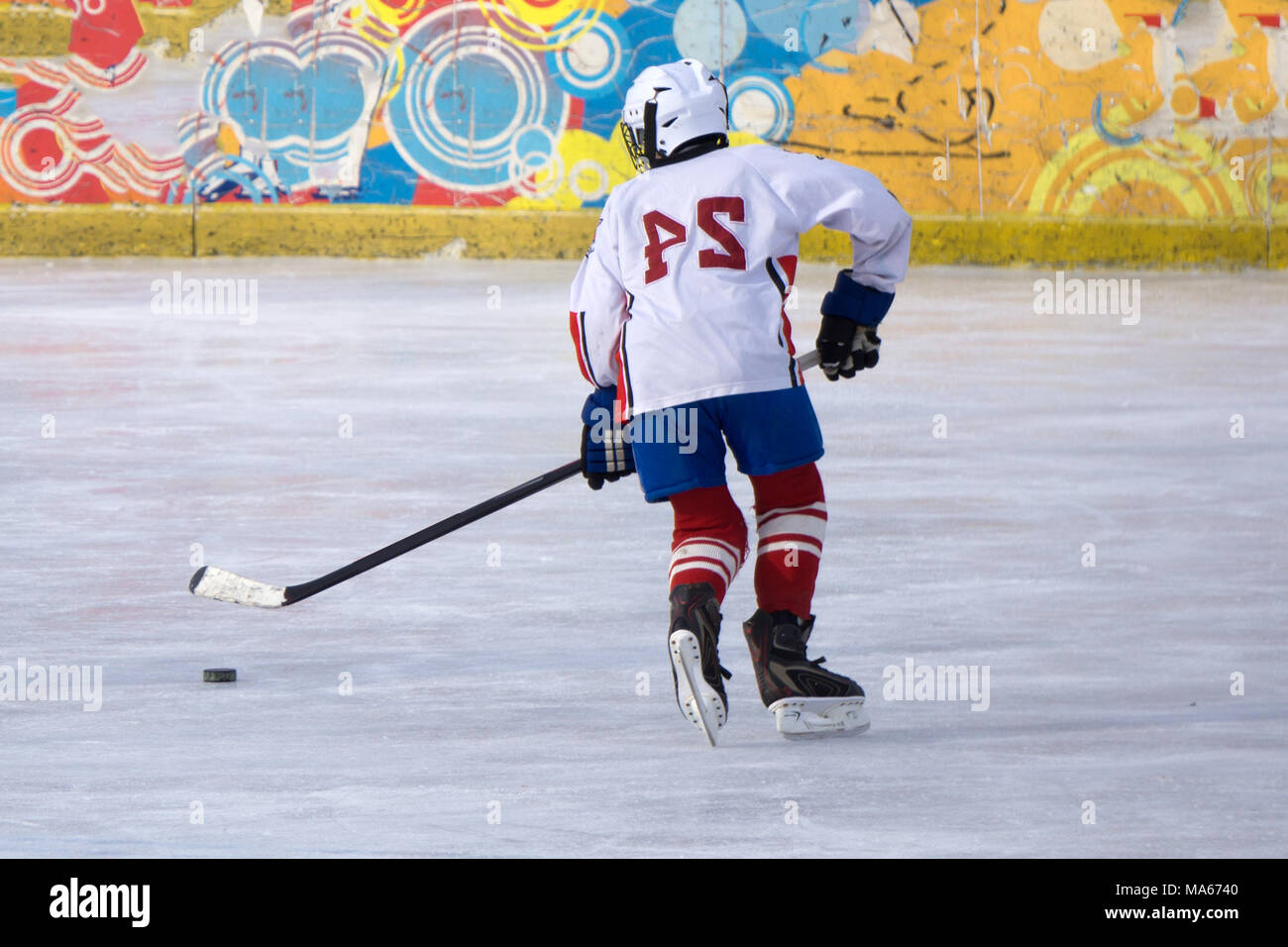 hockey player with a puck on the ice of the blade moves the ice Stock