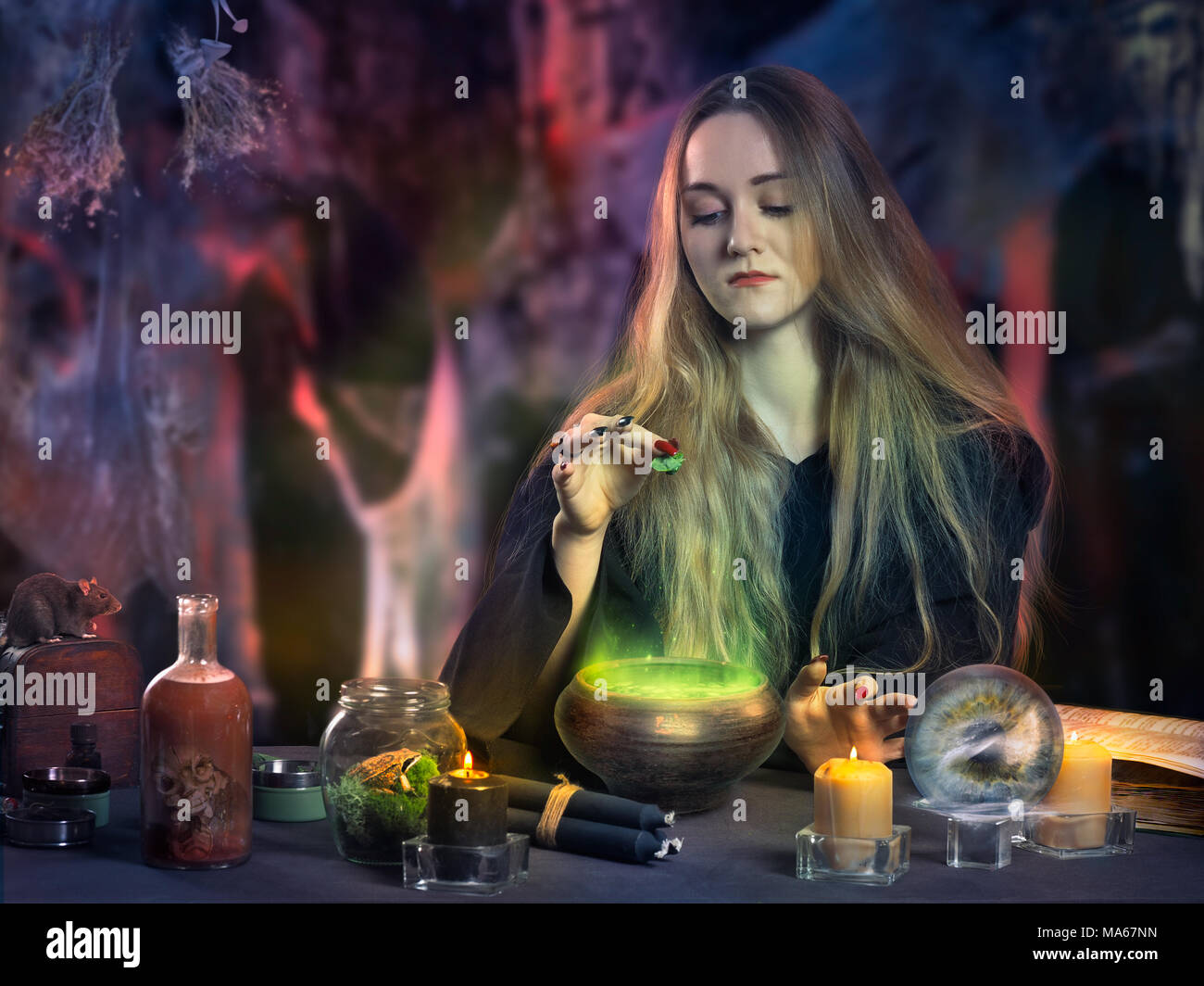 The work of the witch. Young beautiful witch making potions using magical ingredients and spells Stock Photo