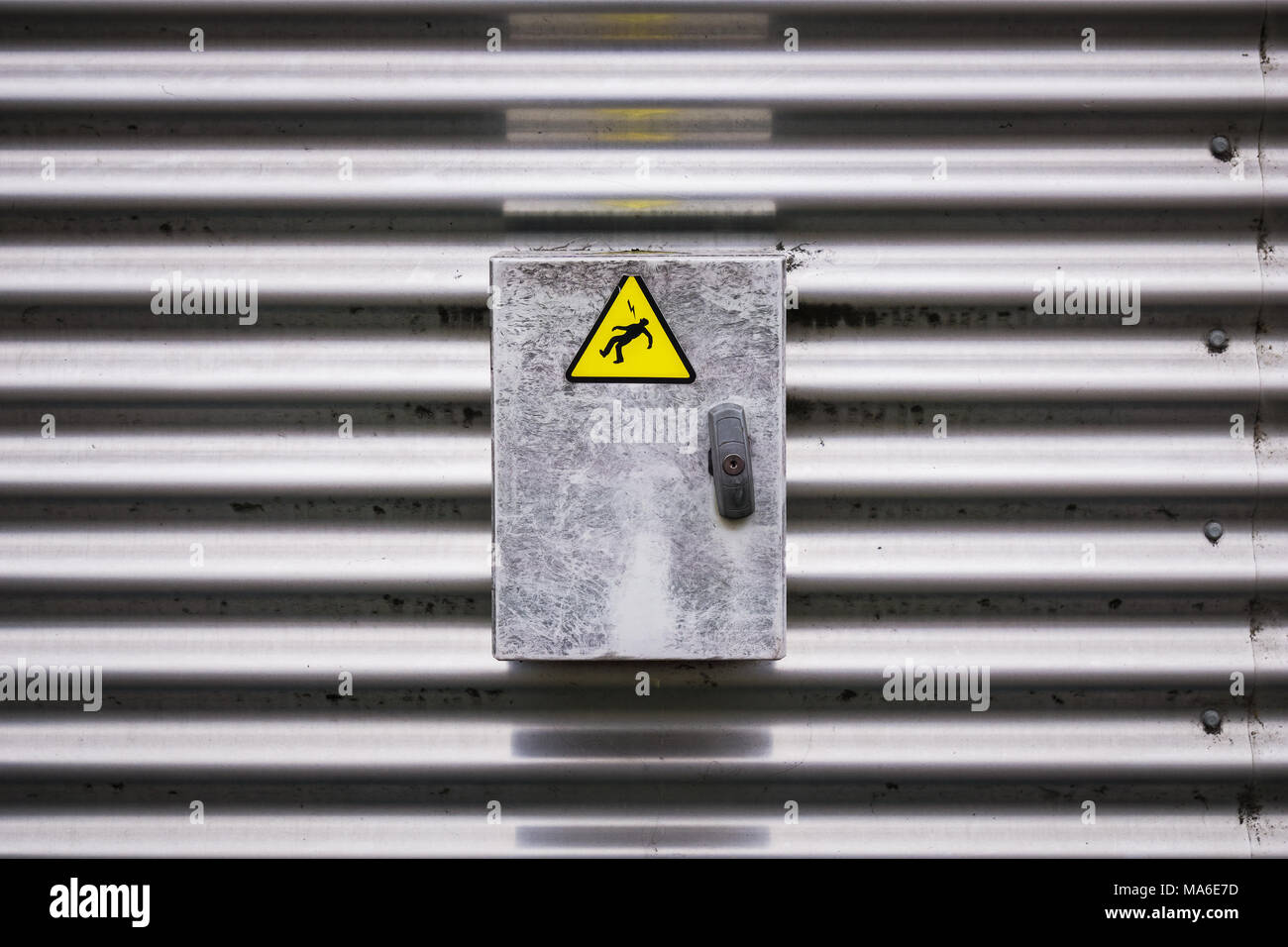 Closeup view of an electric box with a danger sign sticker representing an electrocuted person silhouette. Stock Photo