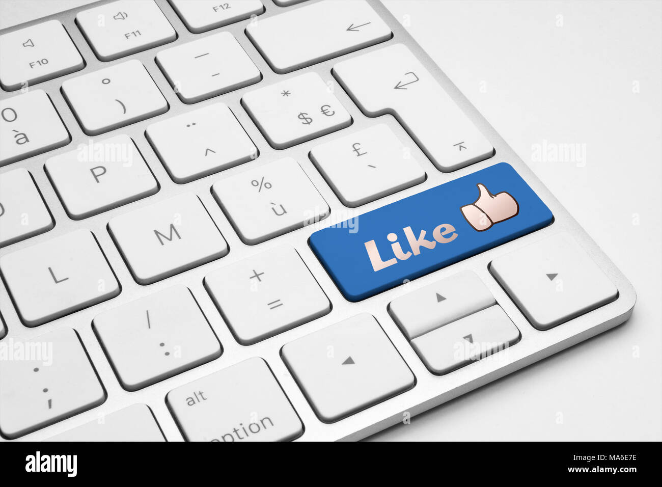 Like blue button with a thumb up icon on a white isolated keyboard. Social media, internet, web and business illustrative concept. Stock Photo