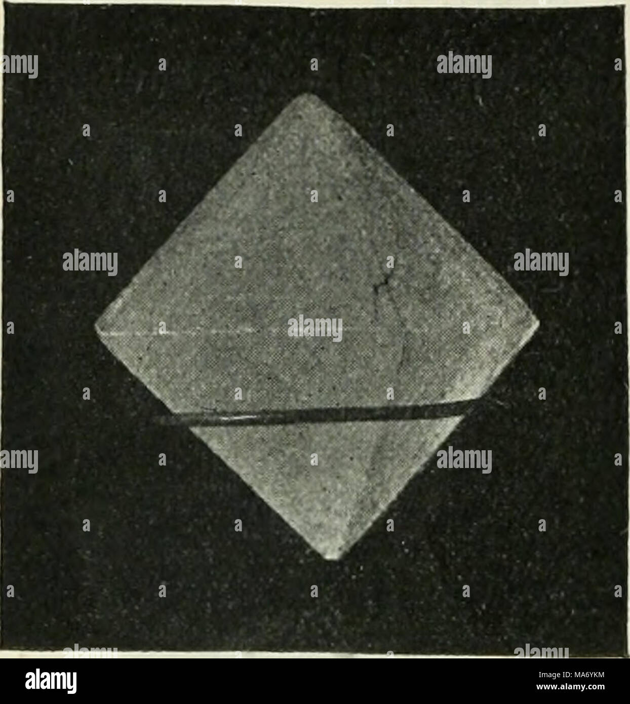 . Elementary physics and chemistry: first stage . Fig. 85.âAn eight-sided crystal of alum. (From a photograph by Mr. H. E. Hadley.) How Crystals can be made.â Warm water when saturated with any soluble substance, as you learnt in a previous lesson, often contains more of the solid dissolved than an equal quantity of a cold saturated solution. The con- sequence of this is, that if you allow a warm saturated solution to get cold, the water can no longer keep all the substance in solution, and it separates out in the solid state, which, under these cir- cumstances, always takes a crystalline char Stock Photo