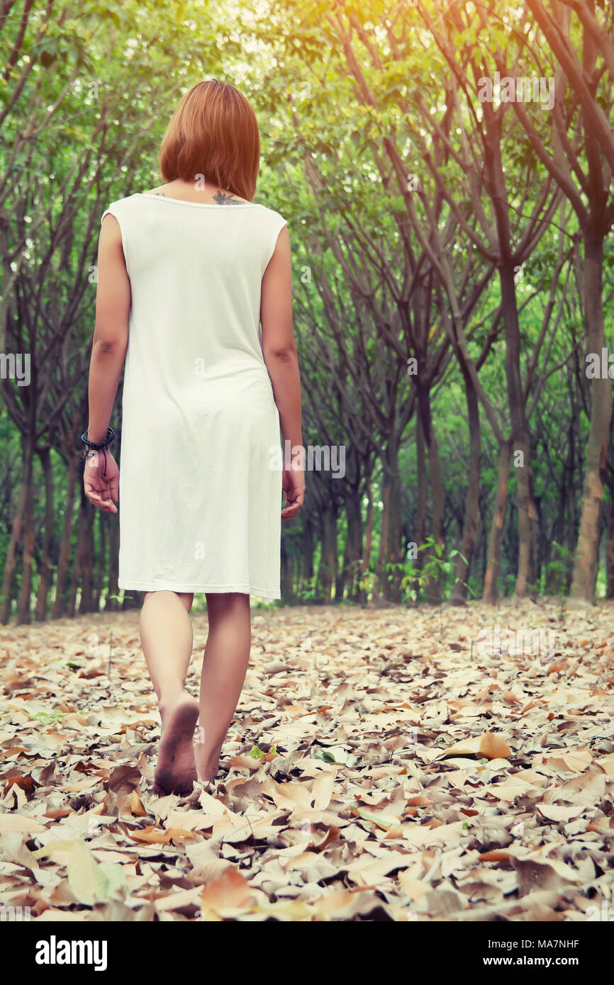 Sad woman walking alone in the forest feeling sad and lonely Stock Photo