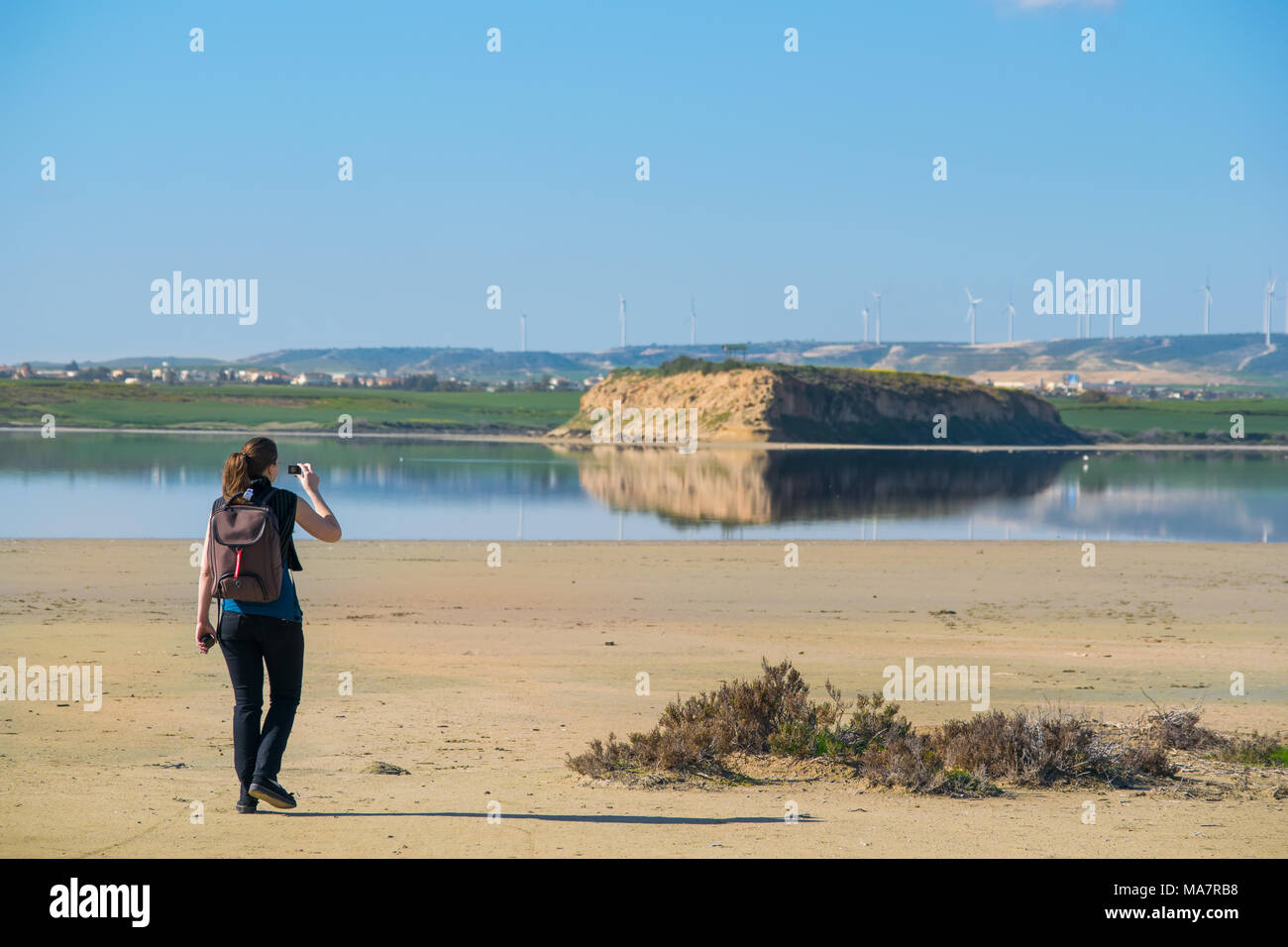 Woman taking pictures on lake shore with action camera in Larnaca Cyprus Stock Photo