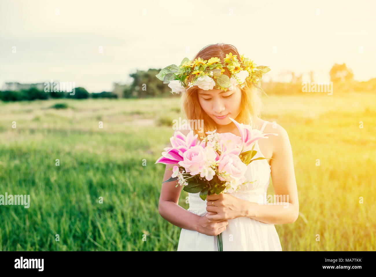 Young beautiful woman smelling pink flowers Stock Photo - Alamy