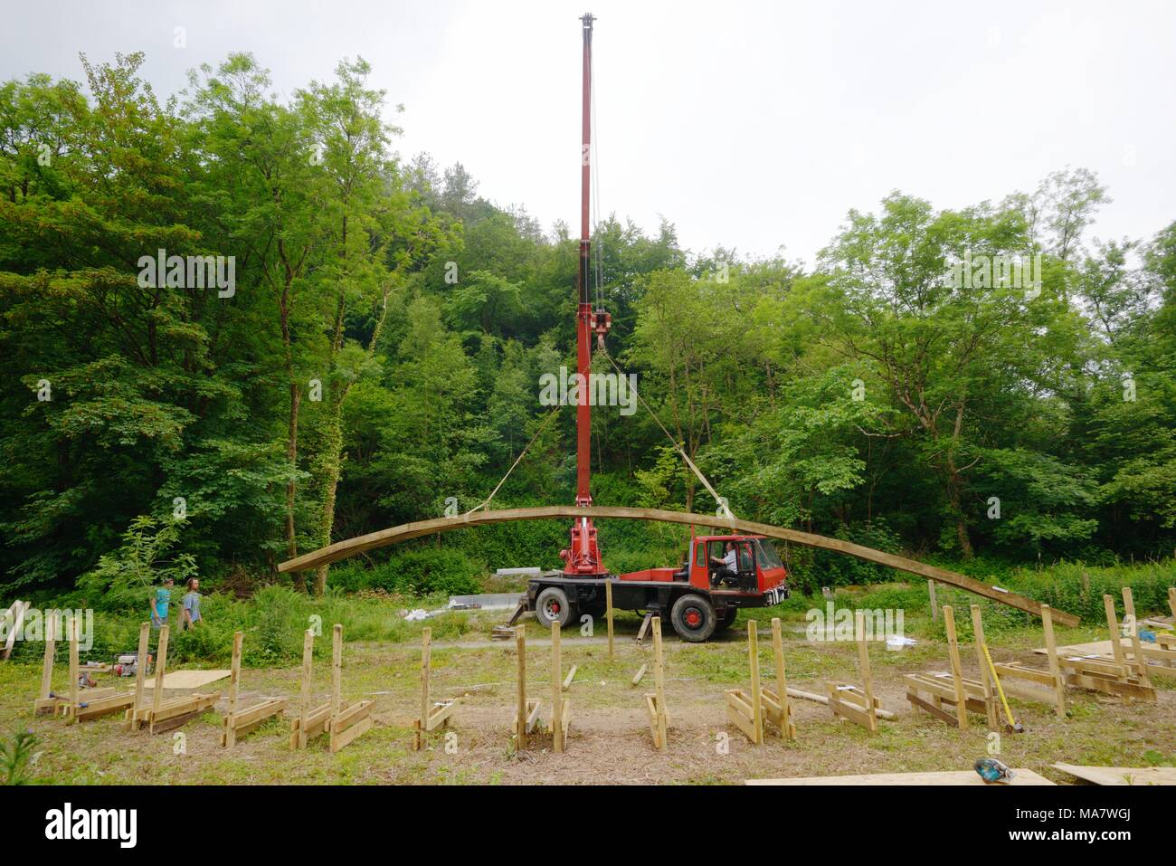 8 in a series of 32, building a timber footbridge. Lifting the complete arch into place using a crane.  Construction of a screw and glue laminated tim Stock Photo