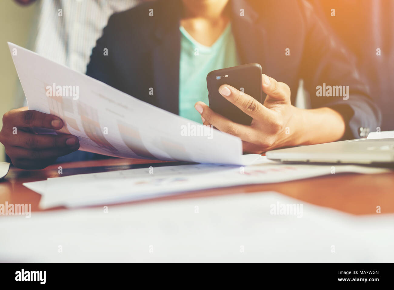 young man working using smartphone and notebook computer, Young man work and typing,financial work,workhard. Stock Photo