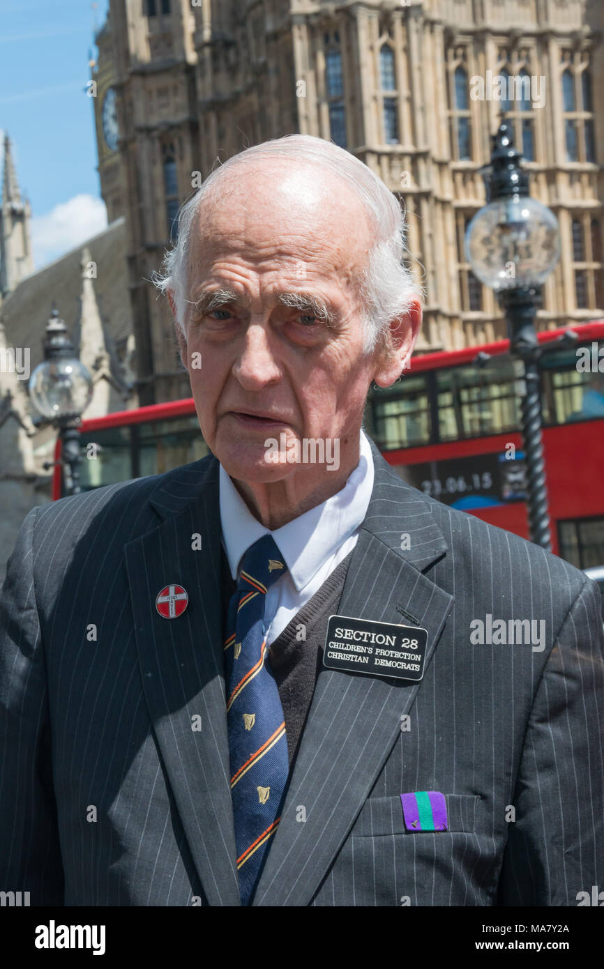 A man wears a badge for anti-gay 'Section 28 Children's Protection Christian Democrats' at the Magna Carta Day protest by right-wing Christian organisation Voice for Justice calling for freedom to express their religious views. Stock Photo