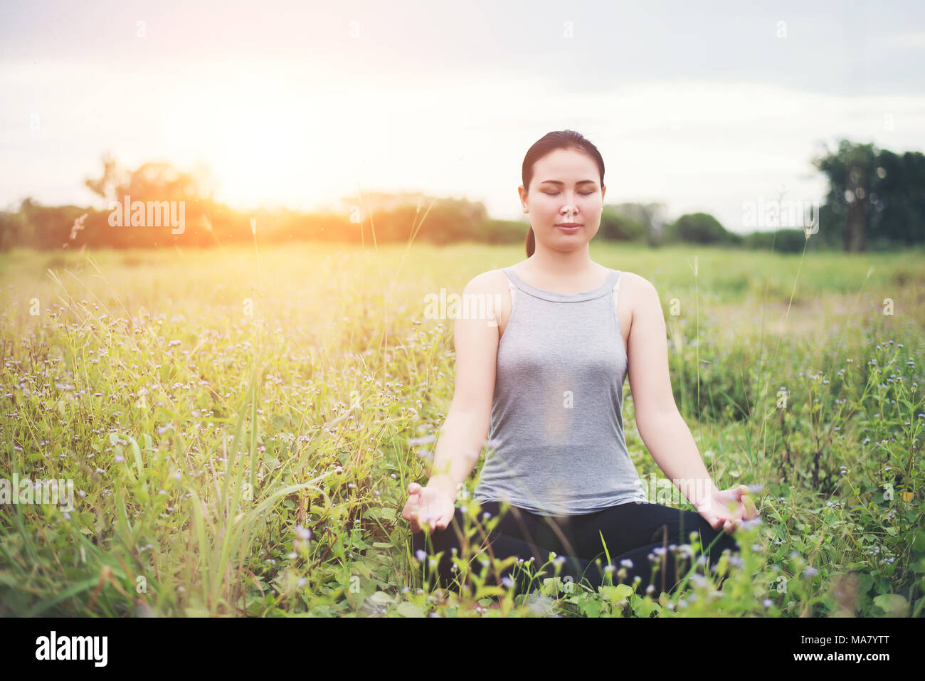 Beautiful woman in lotus position practicing yoga Stock Photo - Alamy