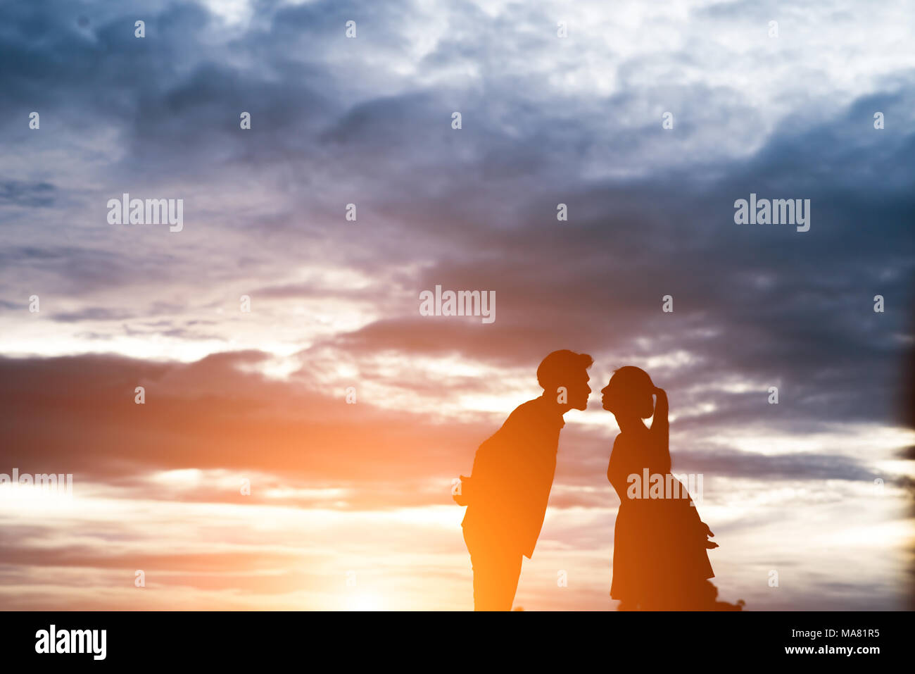 Silhouette of sweet couple kissing over sunset background Stock Photo ...