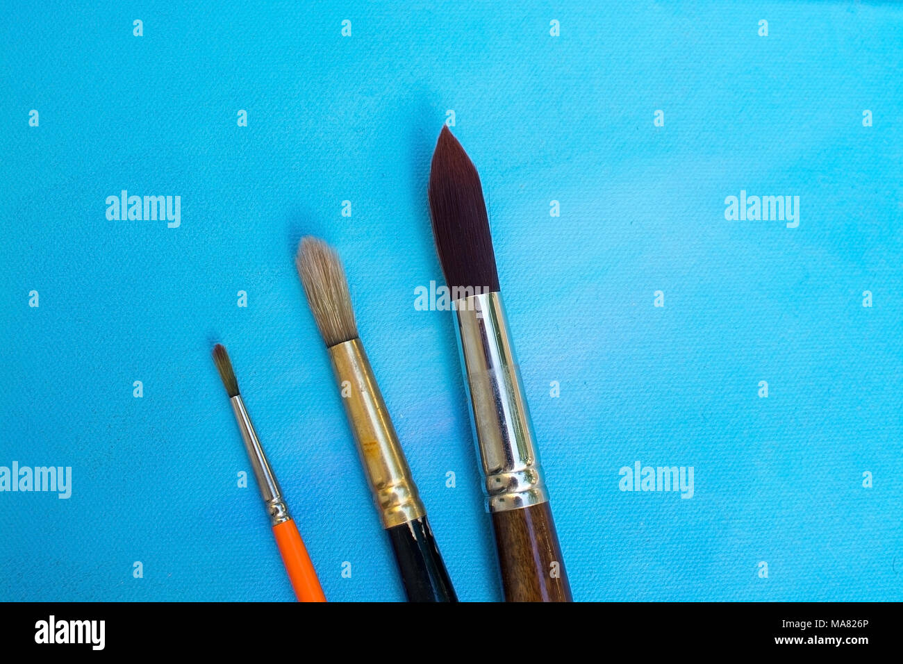 Brushes on blue painted canvas background texture background, concept for grades in school development, creative expression artist concept Stock Photo