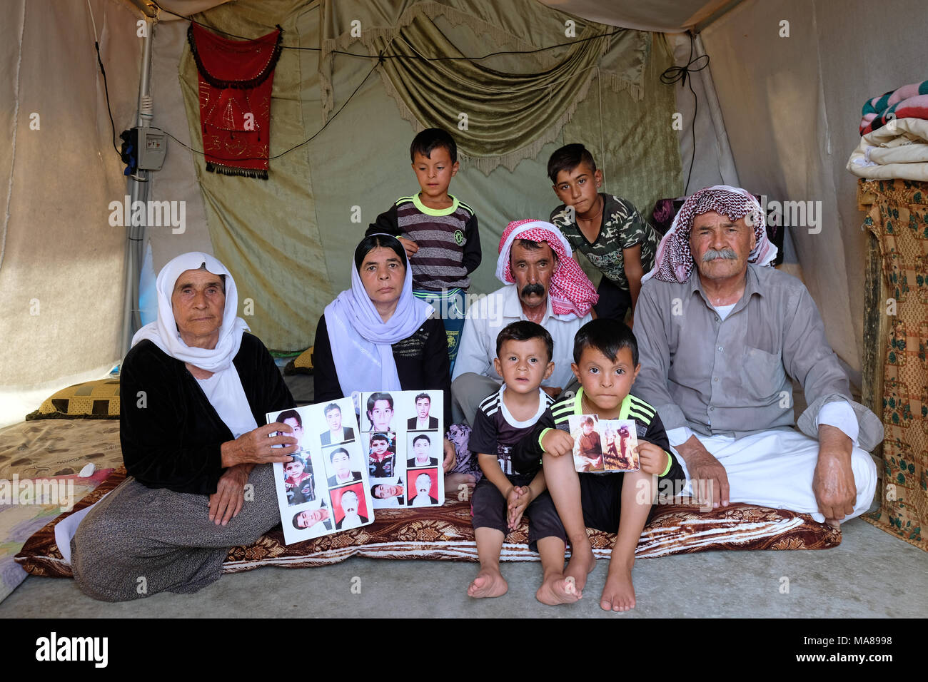 Yezidi IDP family shows photos of their deceased relatives, Sharya Camp near Duhok, Northern Iraq, Kurdistan Autonomous Region, Iraq Stock Photo