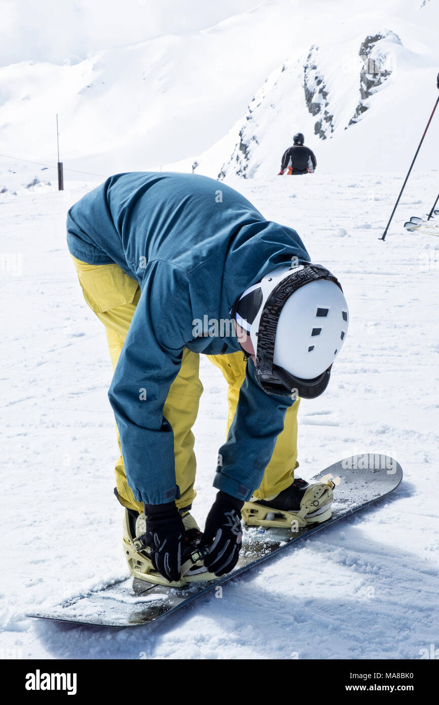 snowboarder fastens snowboard Stock Photo