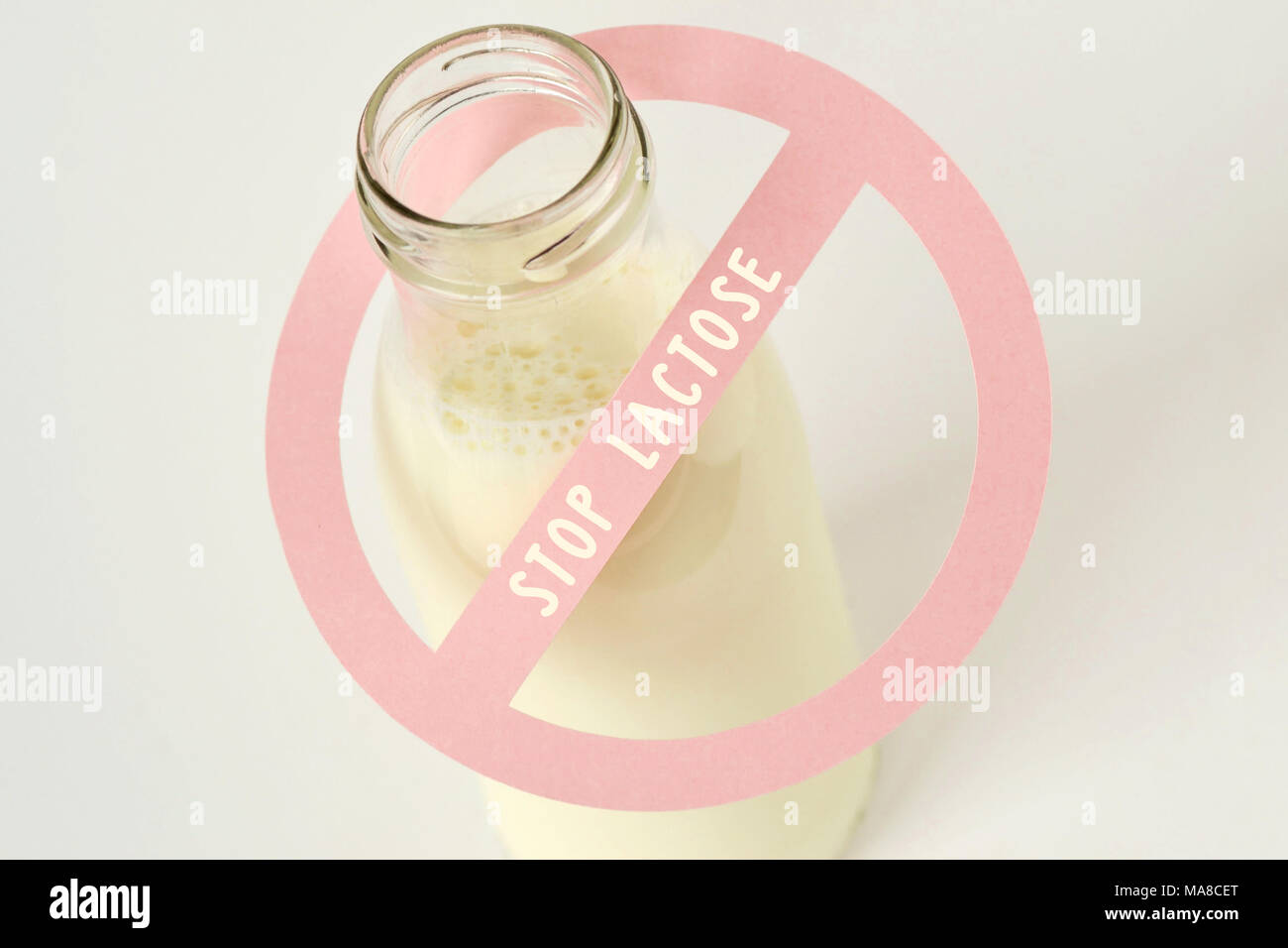 Glass bottle of milk with restriction sign with Stop lactose text