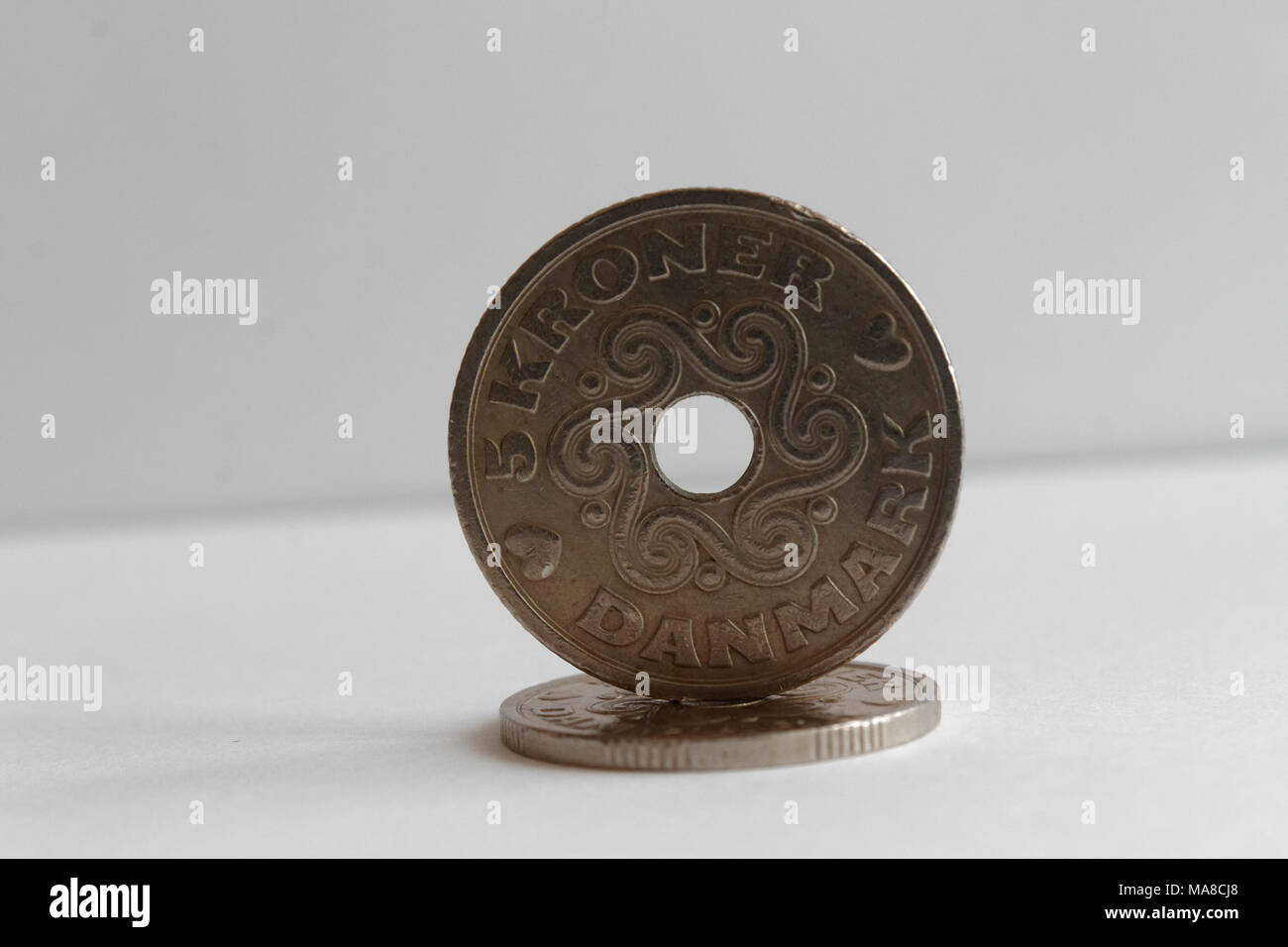 Two Denmark coins lie on isolated white background Denomination is 5 krone (crown) Stock Photo