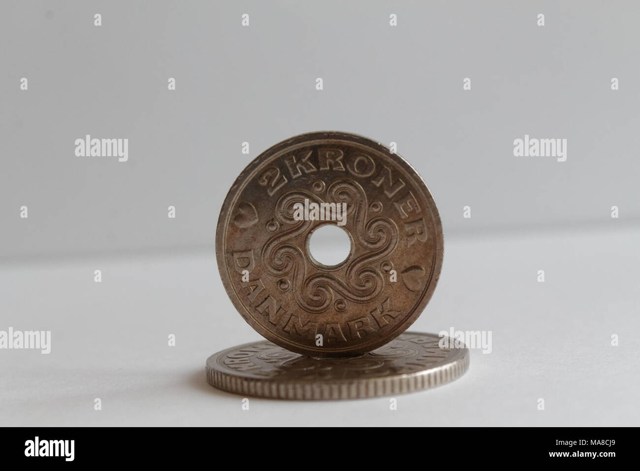 Two Denmark coins lie on isolated white background Denomination is two krone (crown) Stock Photo