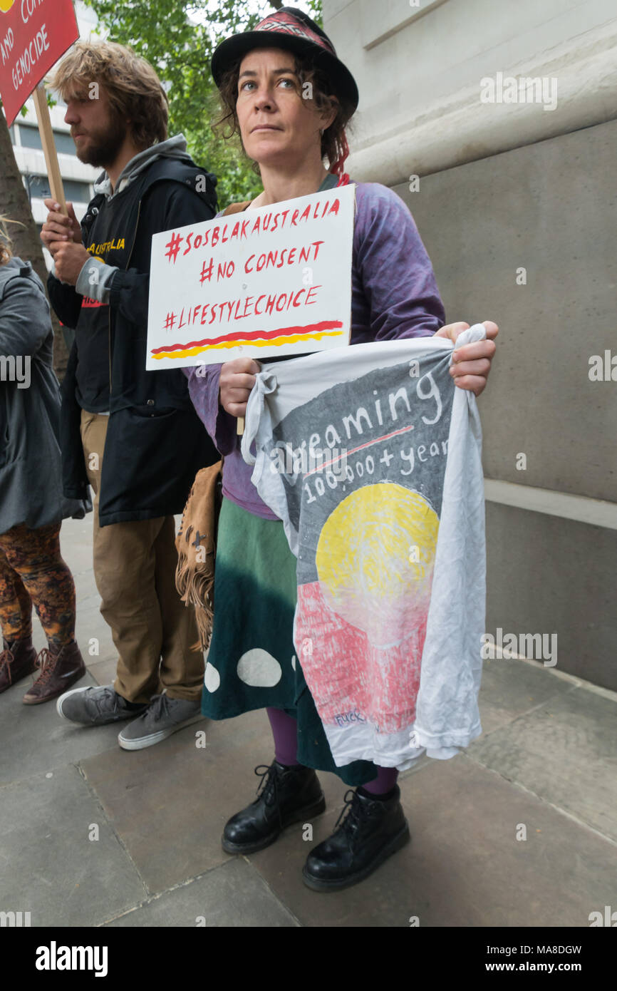 A woman in the protest at Australia House, London demanding an end to forced closure of Aborigine Communities holds a 'Dreaming'  t-shirt with a design based on the the Aboriginal flage Stock Photo