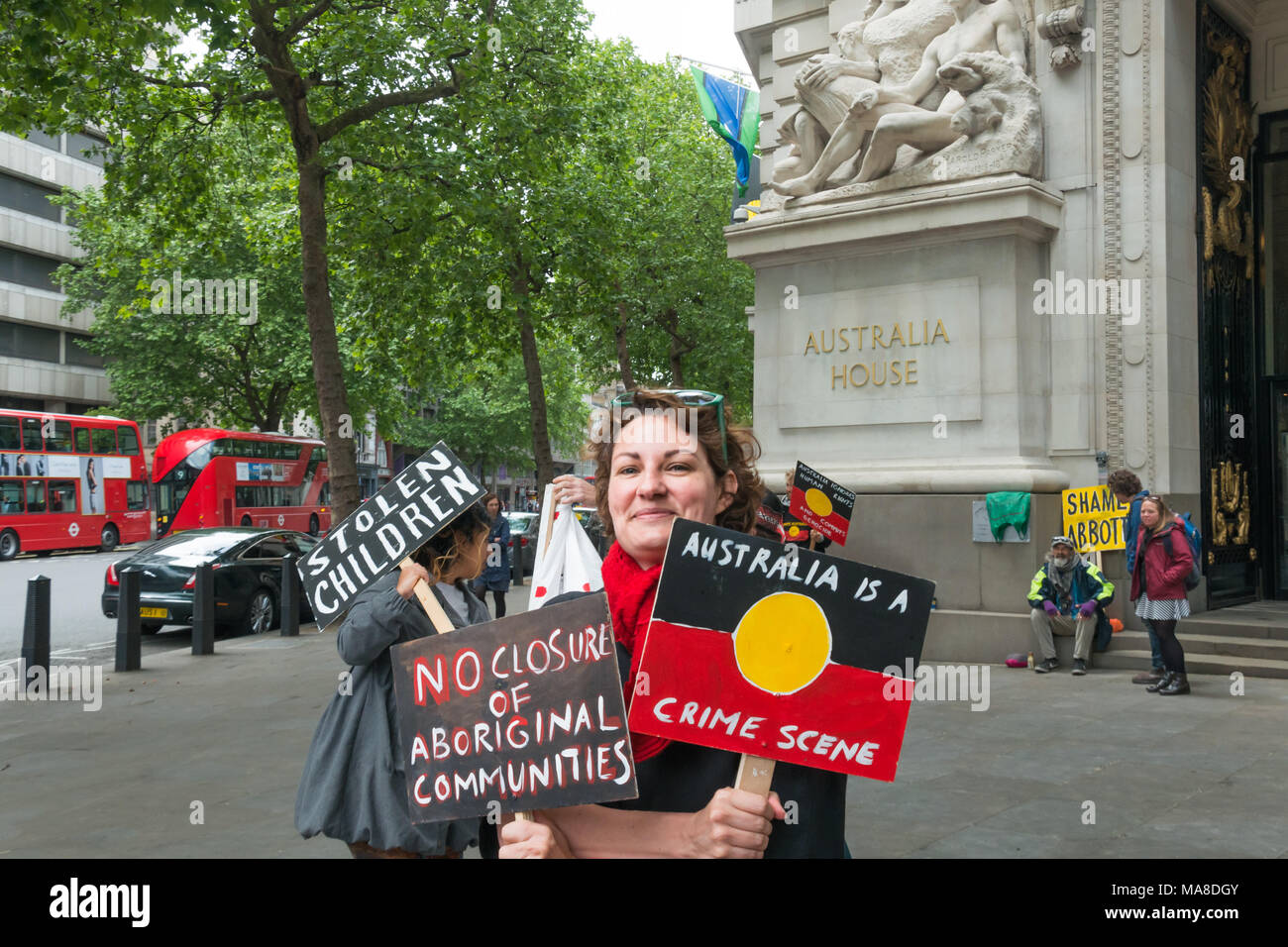 'Australia is a Crimes Scene 'states a placard in the design of the Aborigine flag, and the protester holds a second 'No Closure of Aboriginal Communities at the protest at Australia House, London. Stock Photo