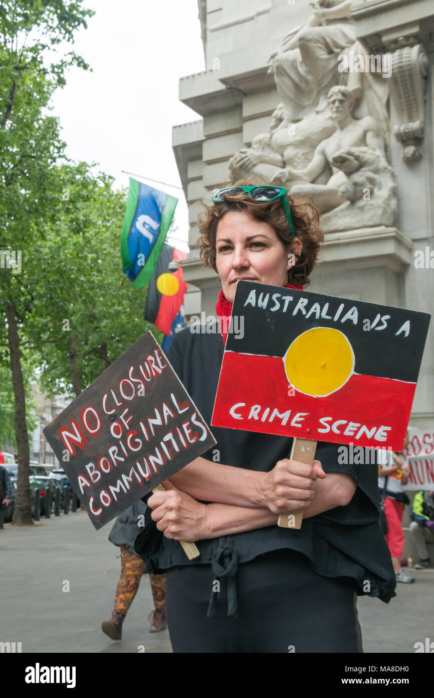 'Australia is a Crimes Scene 'states a placard in the design of the Aborigine flag, and the protester holds a second 'No Closure of Aboriginal Communities at the protest at Australia House, London. Stock Photo