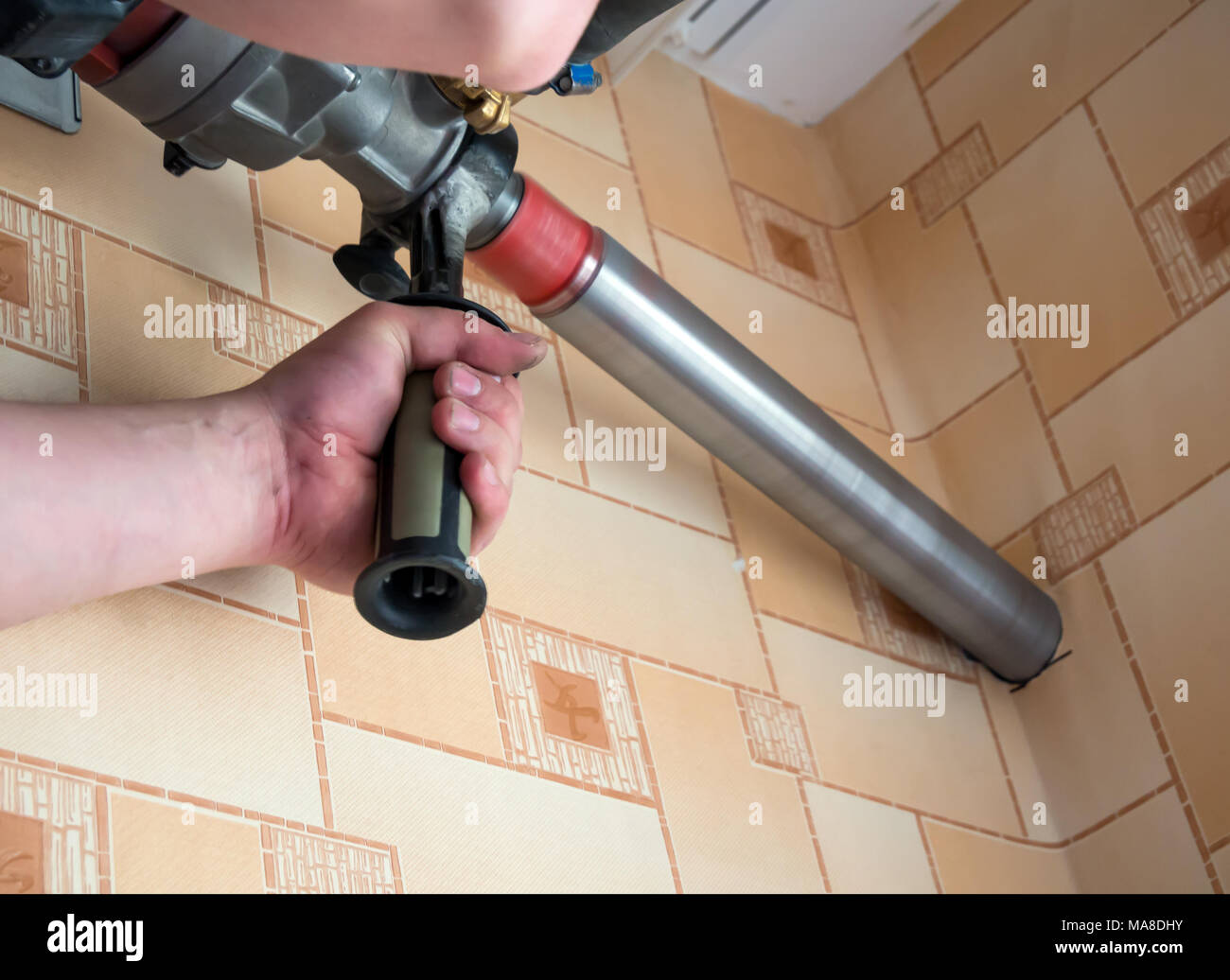 Drilling a large hole in the wall Stock Photo