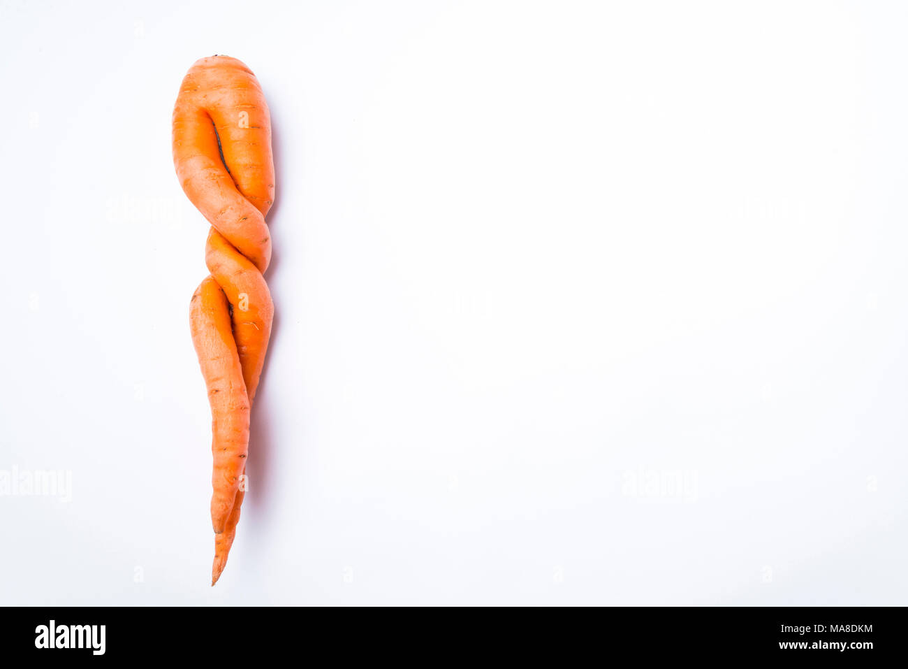 carrots of unusual shape lies on a white background Stock Photo