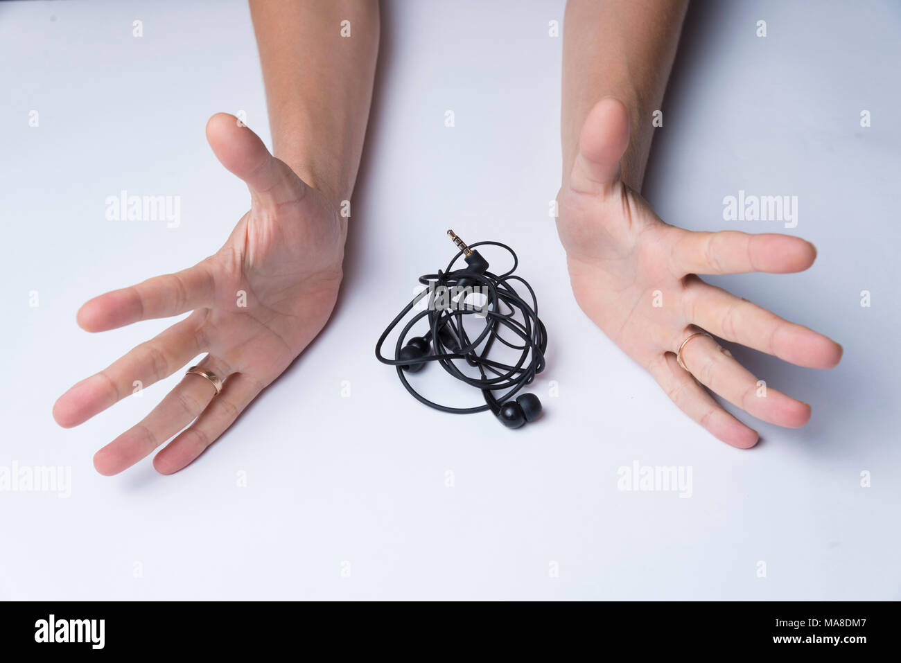 Emotional hand gesture, tangled headphones Stock Photo