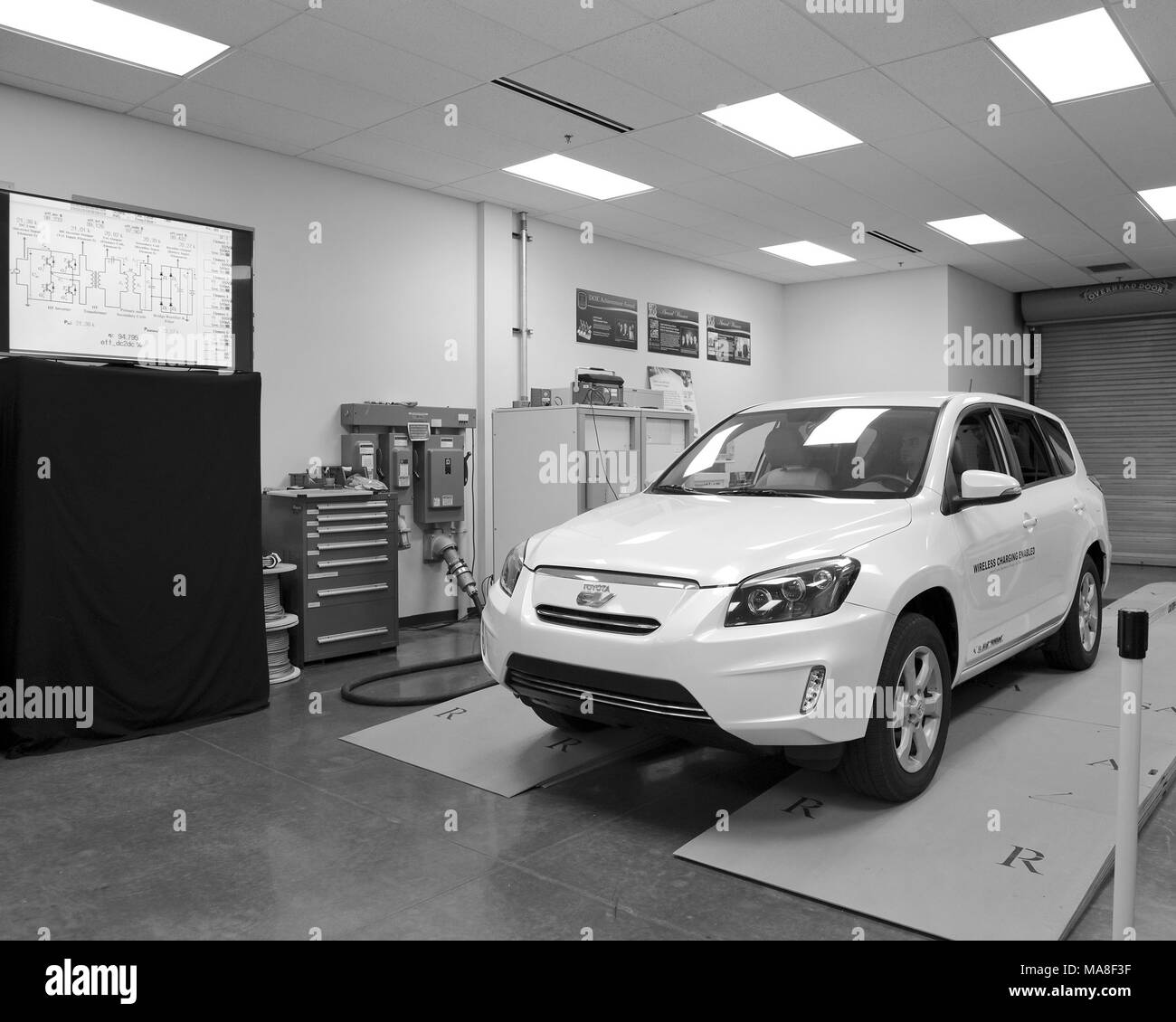 White, Toyota brand, electric car, parked in a laboratory, above a 20-kilowatt, wireless fast-charging system, produced at Oak Ridge National Laboratory (ORNL) image courtesy of the US Department of Energy, 2016. () Stock Photo