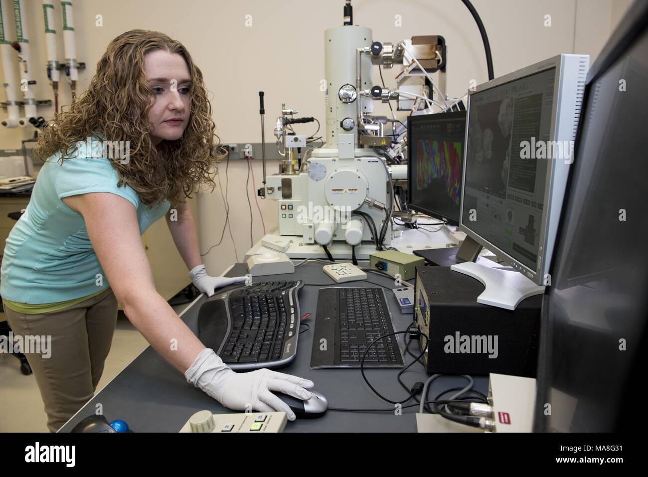 Female researcher uses a Scanning Electron Microscope (SEM) to perform high-resolution, electron microscopy studies of structural materials, in a lab located at Pacific Northwest National Laboratory (PNNL) located in Richland, Washington, image courtesy of the US Department of Energy, November 15, 2016. () Stock Photo