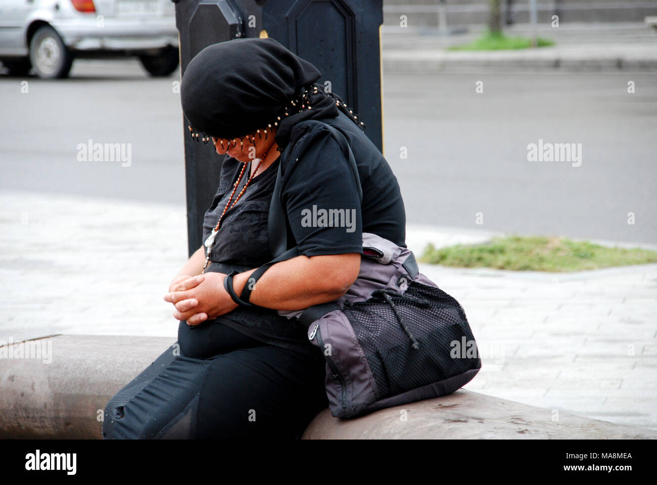 Elderly Georgian woman is sitting asleep on the stone bench at the Europe Square in Batumi, Adjara, Georgia. Stock Photo