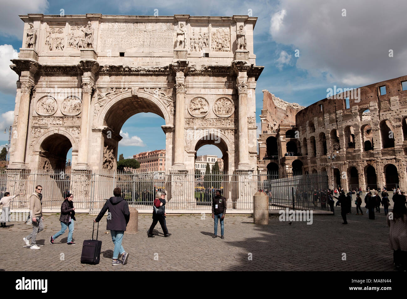 A tourist with a suitcase admires the Arch of Constantine, Arco di Costantino, Rome Stock Photo