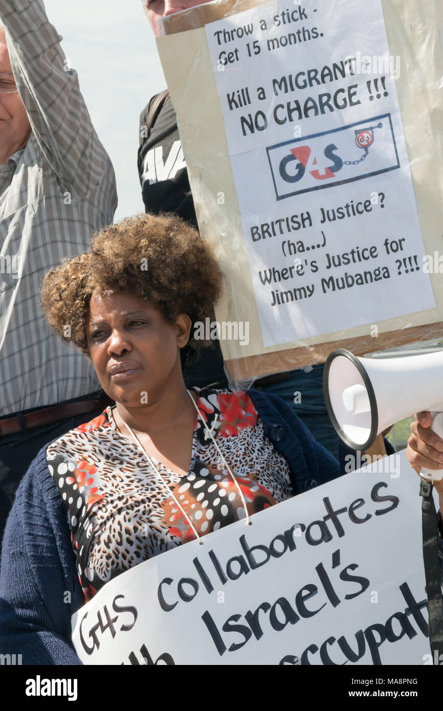 Protesters and placards at the Stop G4S protest outside G4S AGM at Excel London. One of them asks where is the justice for Jimmy Mubenga, killed in an enforced deportation by G4S staff. Stock Photo
