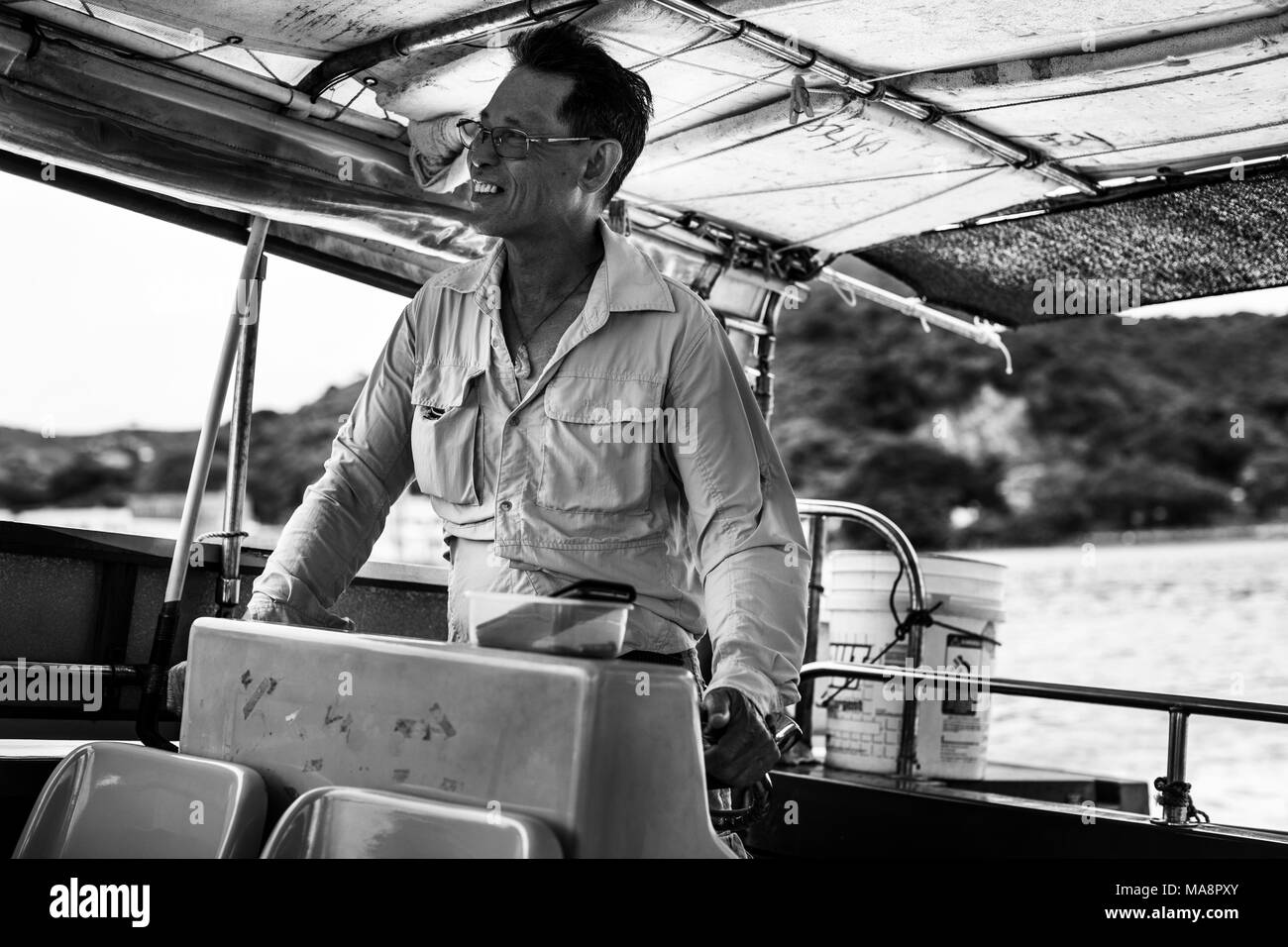 A man drives a tourist boat to look for white dolphins from the fishing village of Tai O, Hong Kong Stock Photo