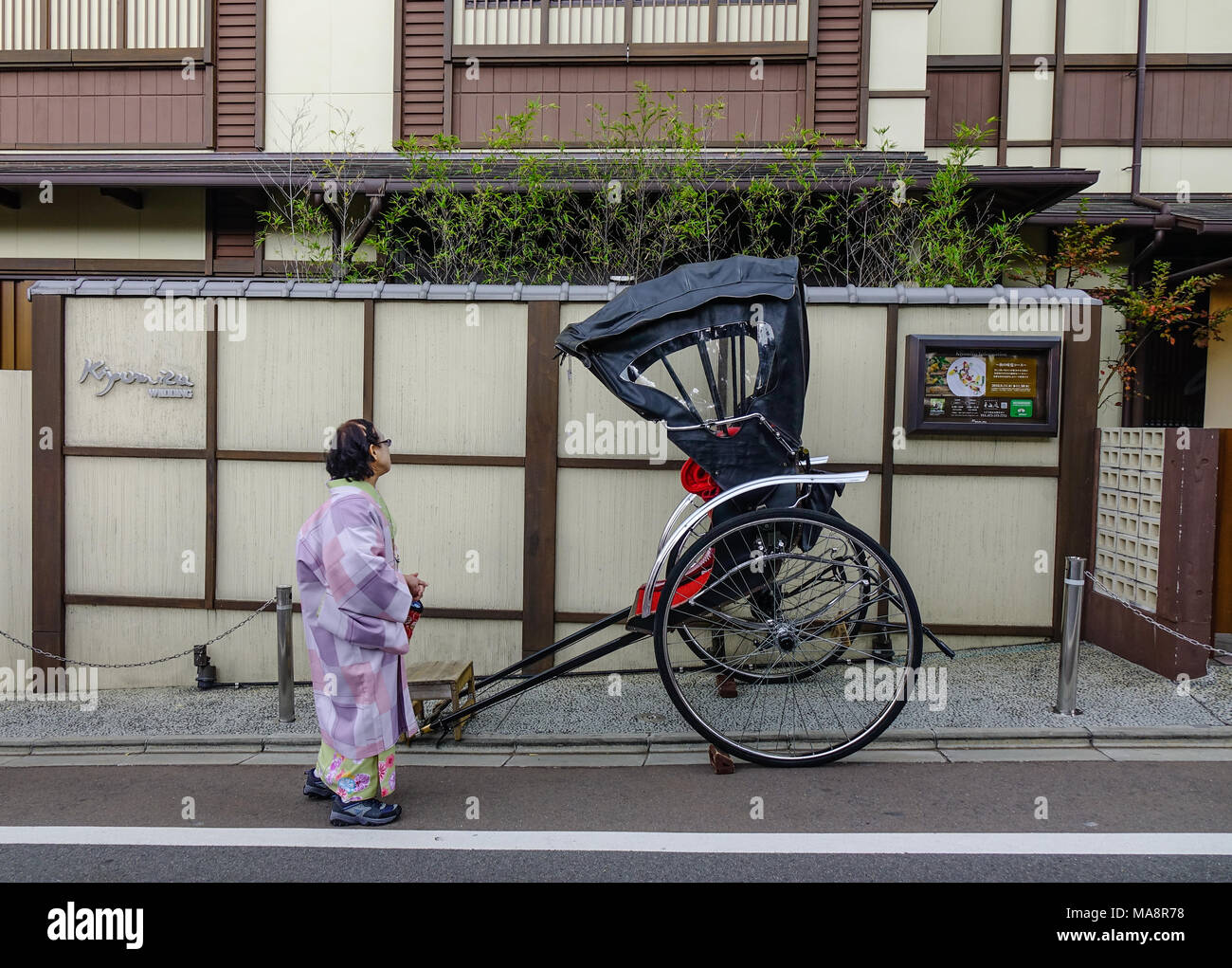 Kyoto, Japan - Nov 29, 2016. A woman with rickshaw on street at old town in Kyoto Japan. Kyoto was the capital of Japan for over a millennium. Stock Photo
