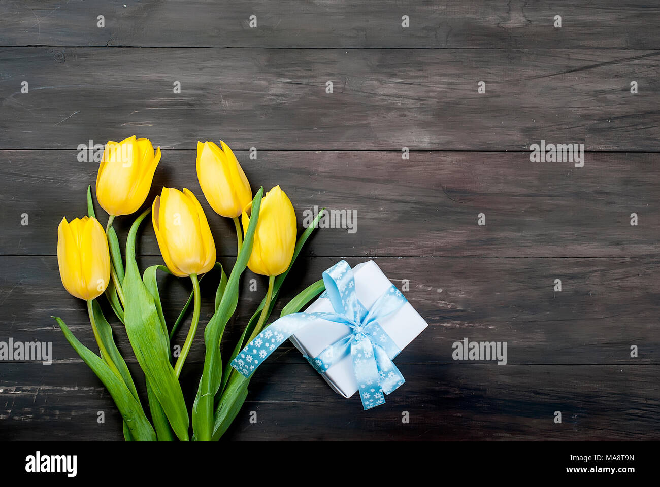 bouquet of yellow tulips and toys chikken easter eggs with a blue ...