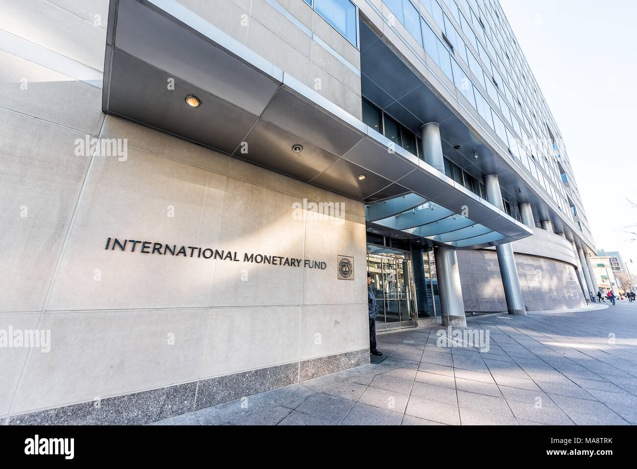 Washington DC, USA - March 9, 2018: IMF entrance with sign of International Monetary Fund, concrete architecture building wall security guard doors Stock Photo