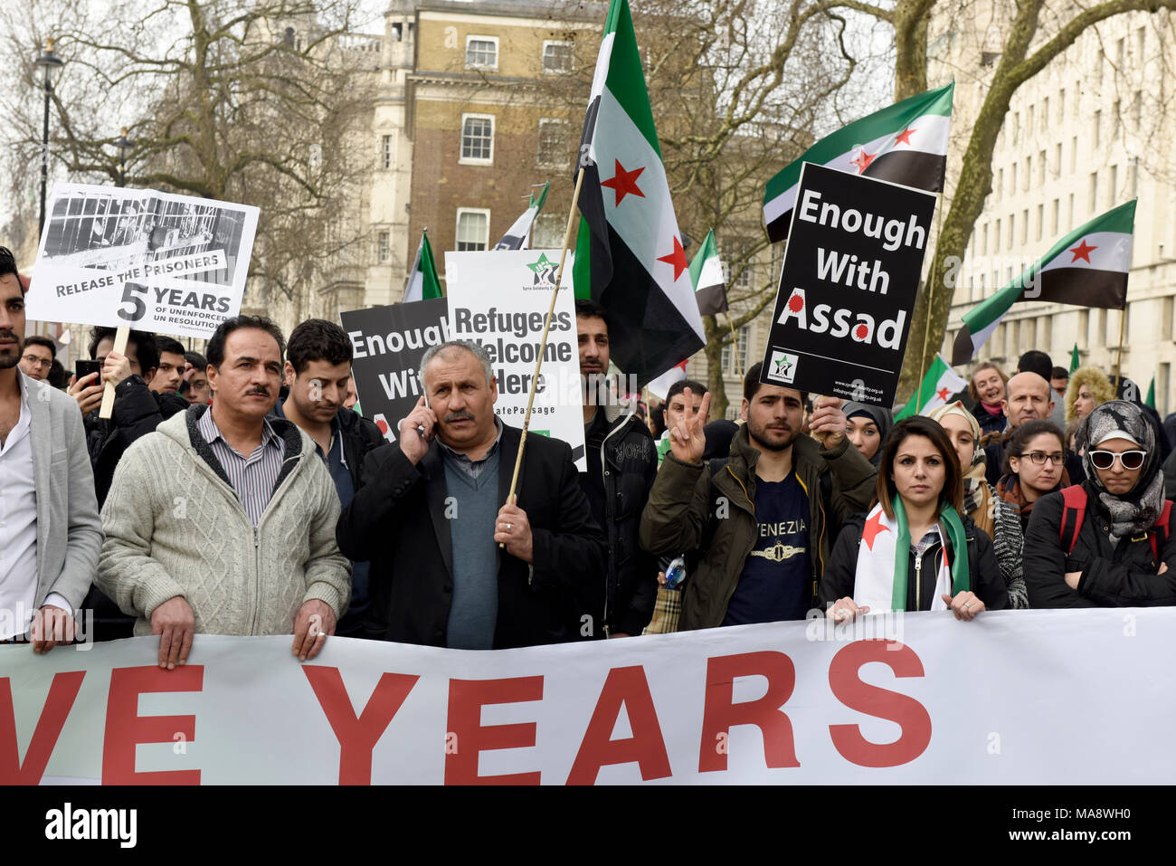 Syrian protesters are holding placards while demonstrating against the Assad regime outside the Downing Street in London, UK. Stock Photo