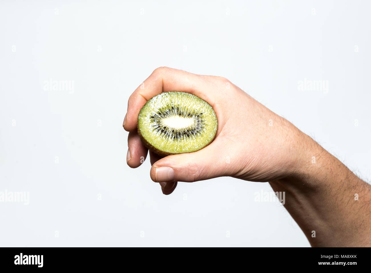 A kiwi cut in a hand Stock Photo Alamy