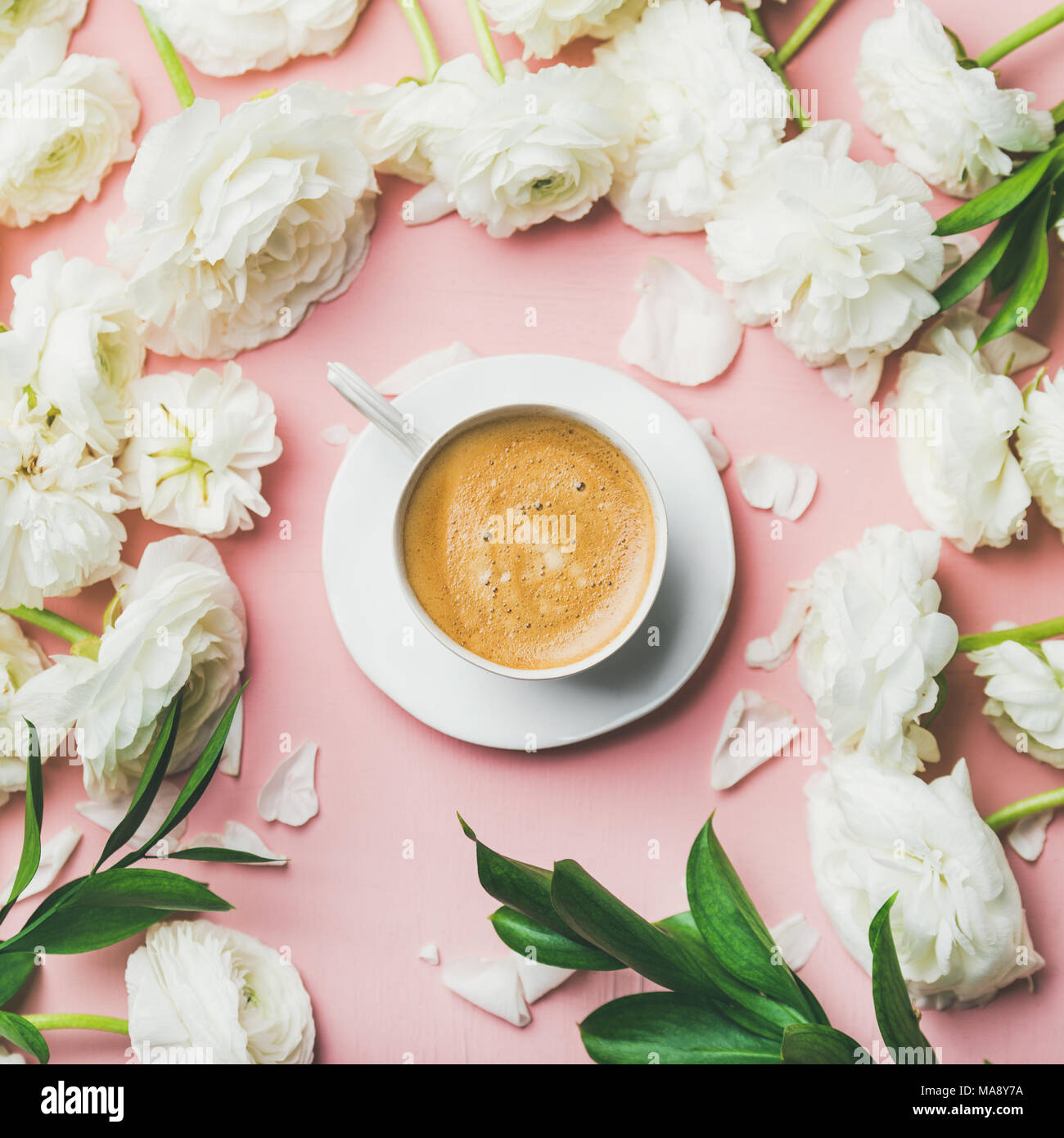 Cup of coffee and ranunculus flowers on light pink background Stock Photo