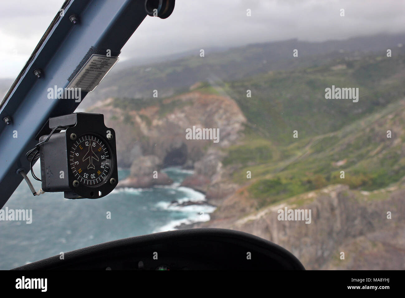 View from the Copilot's seat of a helicopter flying over the coat of the island of Maui in the Hawaiian Islands. Stock Photo