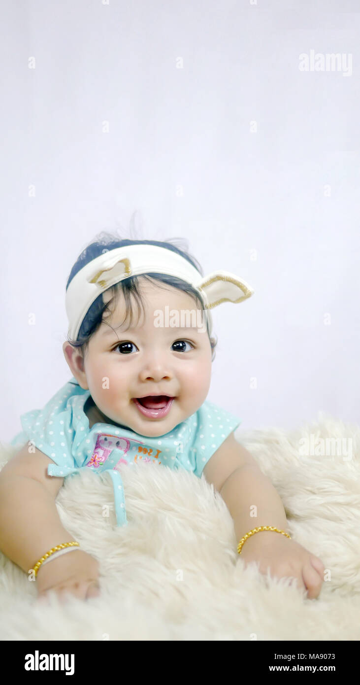 Asian Smiling baby girl crawling in bedroom Stock Photo