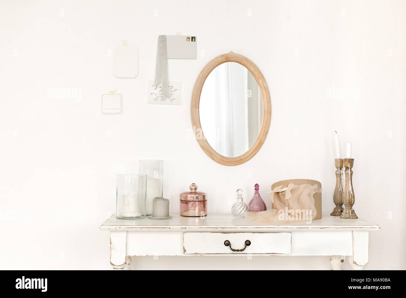 White colored vintage table and mirror hanging on the wall Stock Photo