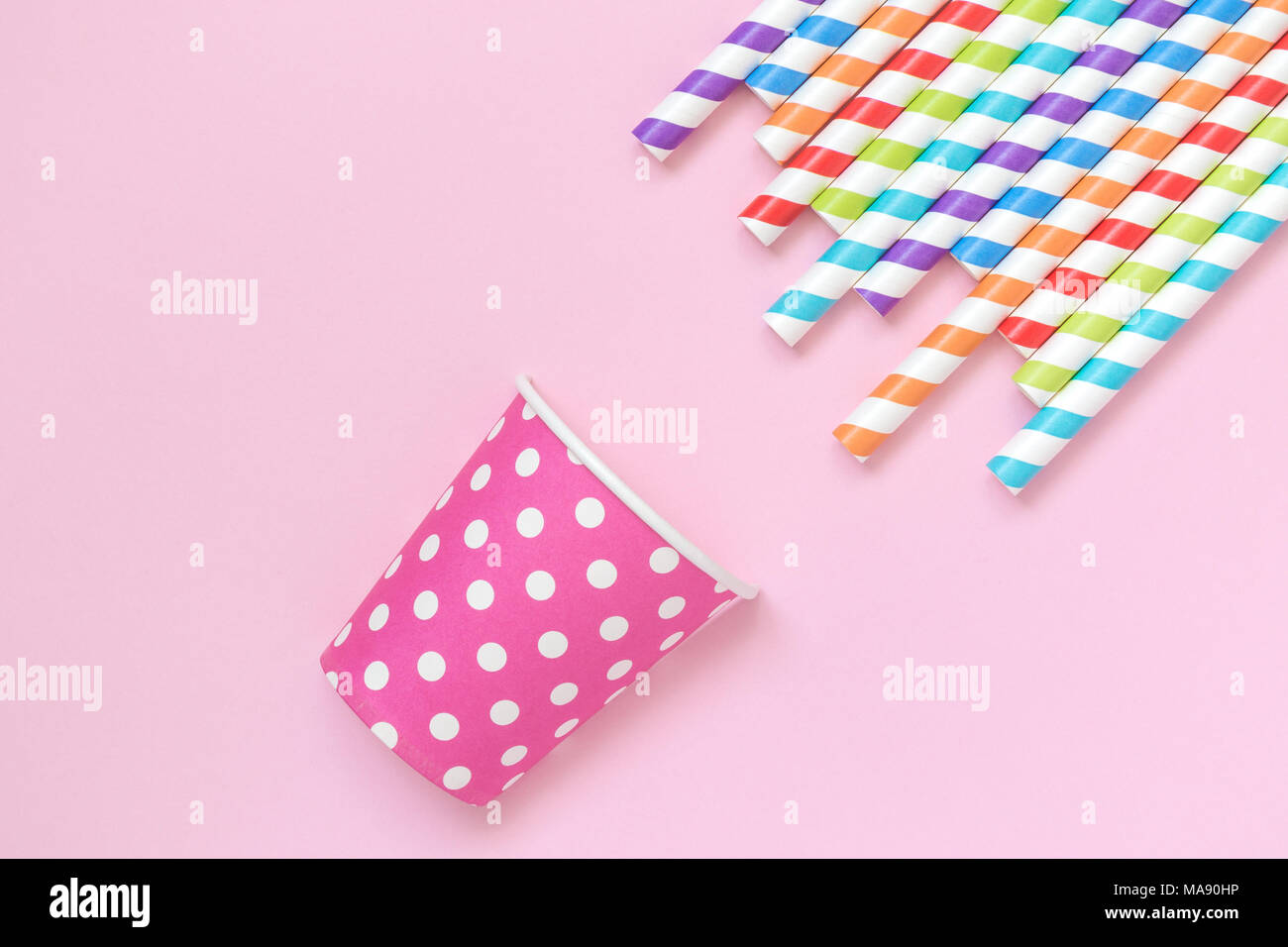 Colorful striped drinking straws and paper cup polka design on pastel ...