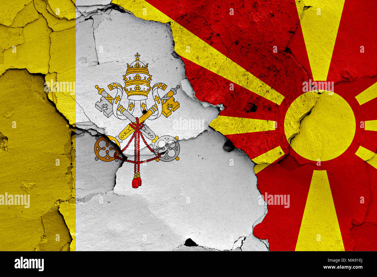 flags of Vatican and Macedonia painted on cracked wall Stock Photo